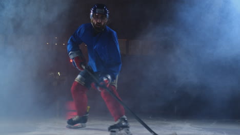 Ein-Mann,-Der-Einen-Eishockeyspieler-Mit-Einem-Puck-Auf-Der-Eisarena-Spielt,-Zeigt-Beim-Dribbeln,-Wie-Er-Sich-Direkt-Auf-Die-Kamera-Zubewegt-Und-Direkt-In-Die-Kamera-Schaut